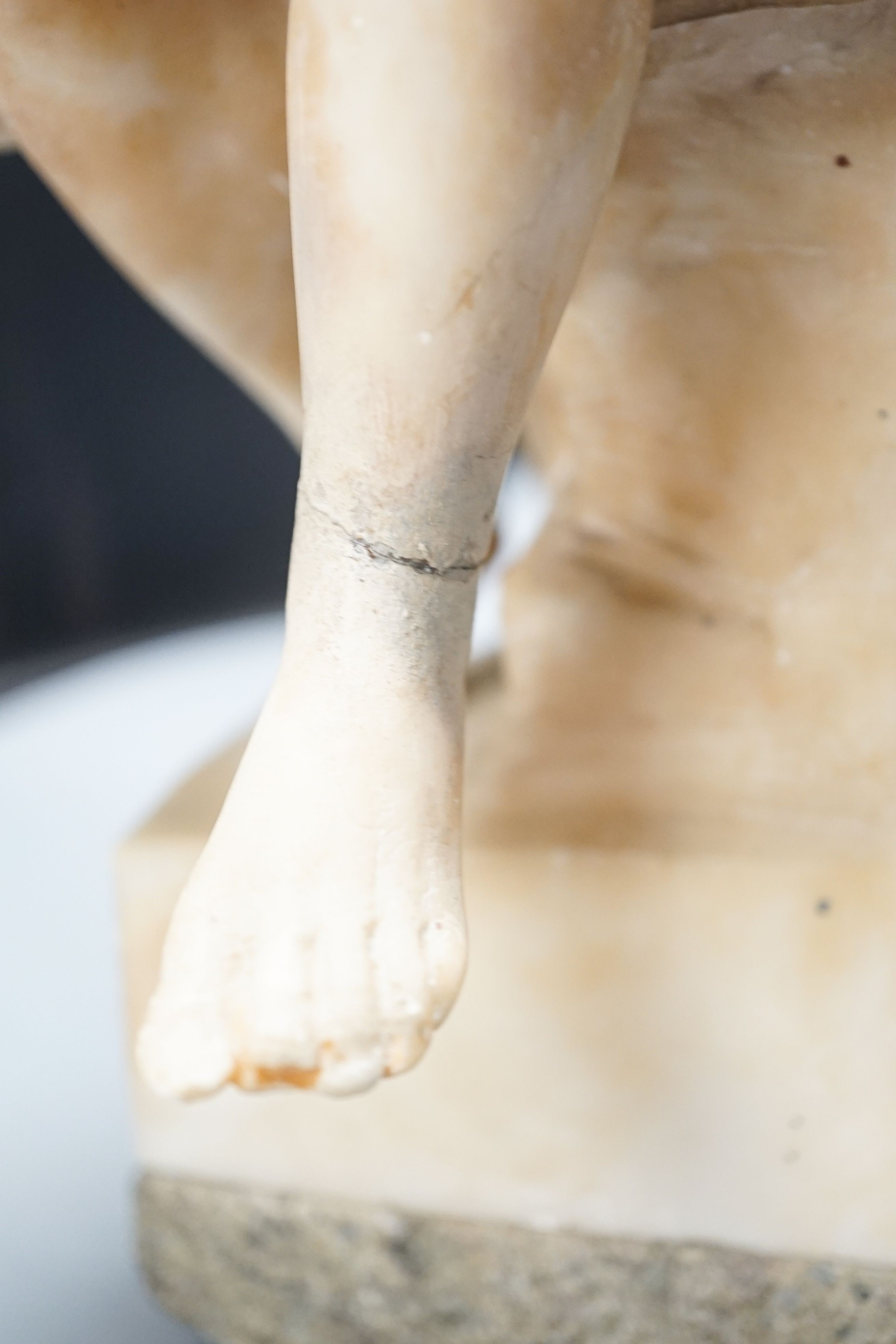 A late 19th century Italian carved alabaster figure of a girl seated, writing at a pillar 47cm
